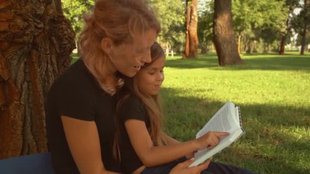 Vrouw leest het boek met haar kind — Stockvideo