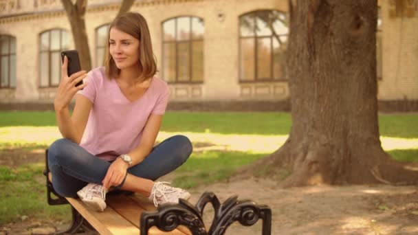 Mladá žena si selfie poblíž college — Stock video