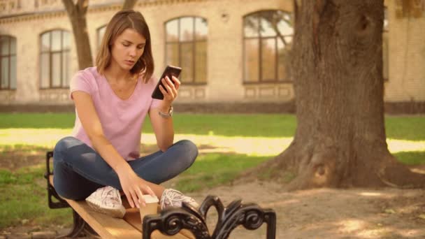 Jovem mulher usar smartphone perto da faculdade — Vídeo de Stock