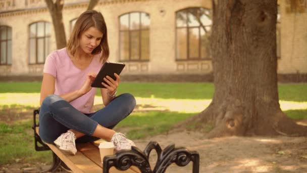 Jovem mulher usar gadget ao ar livre — Vídeo de Stock