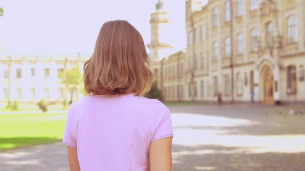 Junge Frau läuft in der Nähe der Universität — Stockvideo