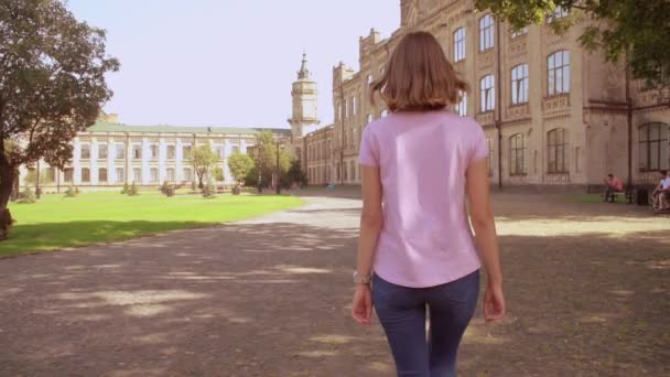 Happy woman walks near university — Wideo stockowe