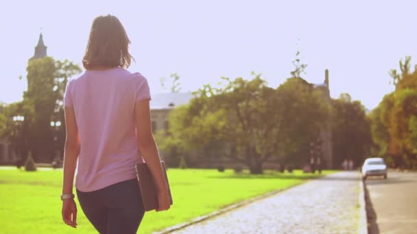 Mujer casual camina en el área del campus — Vídeos de Stock
