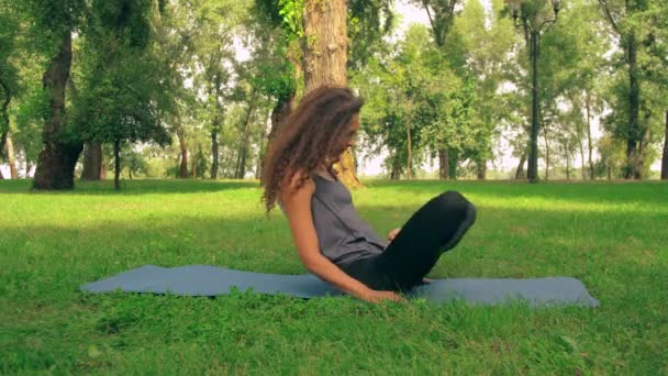 Junge schlanke Frau macht Yoga im Freien — Stockvideo