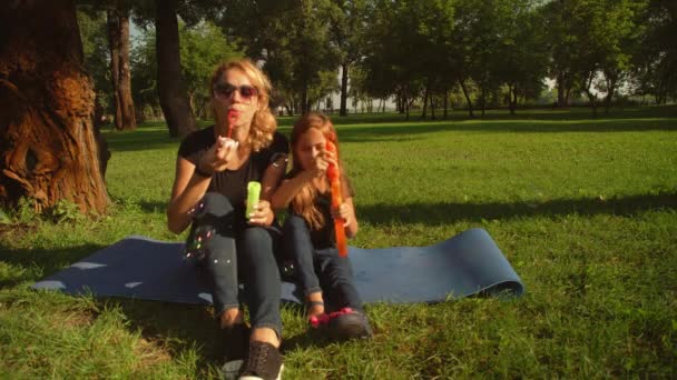 Front view of a family blowing soap bubbles — Stock Video