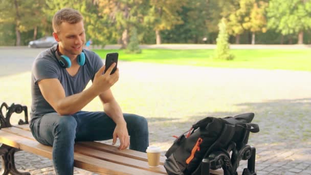 Happy men texting message in park — Stock Video