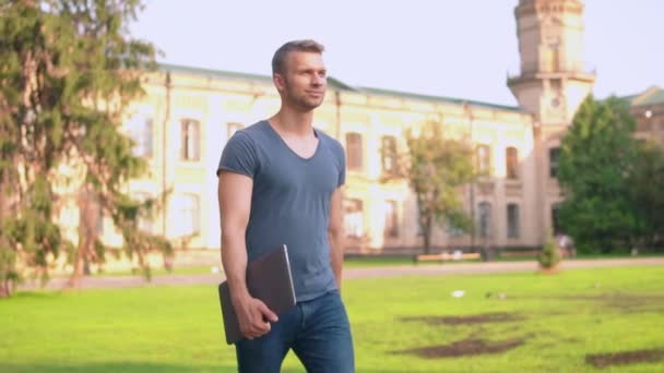 Successful cheerful guy walks in campus area — Stock Video