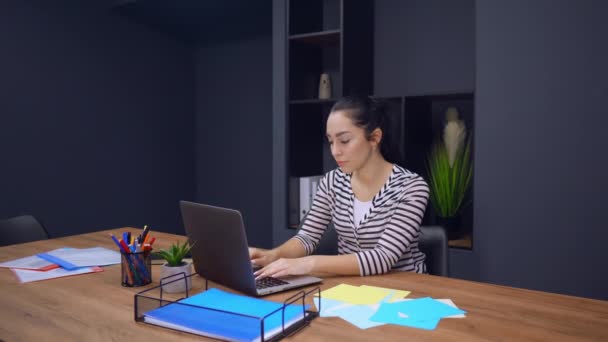 Employee in startup company use computer looks on the viewers — Stock Video