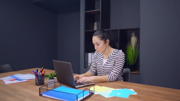 Młoda, odnosząca sukcesy bizneswoman korzystająca z laptopa w biurze — Wideo stockowe