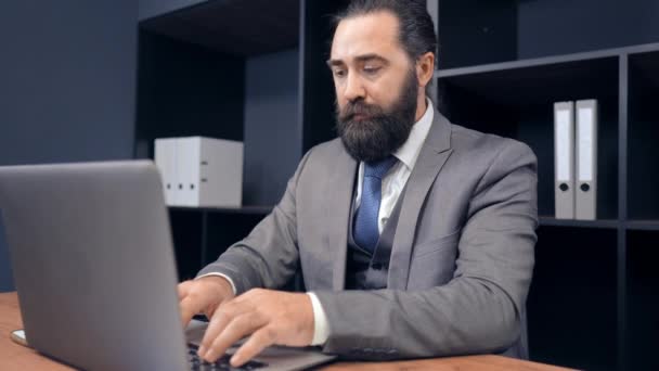 Drukke man in kantoor kamer controletaken in de computer en praten op de telefoon. — Stockvideo