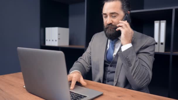 Уверенный бизнесмен, работающий в офисе, сидит за столом — стоковое видео