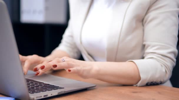 Close-up vrouw met rode nagels is te tikken toetsenbord van de laptop. — Stockvideo