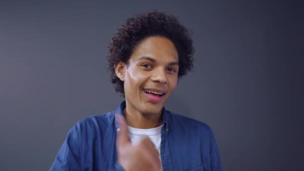 Curly afroamericano chico mostrando pulgar hacia arriba en fondo del estudio . — Vídeos de Stock