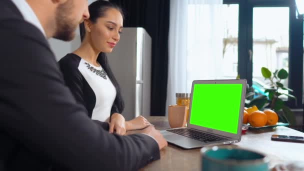 Dois colegas de trabalho estão olhando para laptop com tela verde e rir — Vídeo de Stock