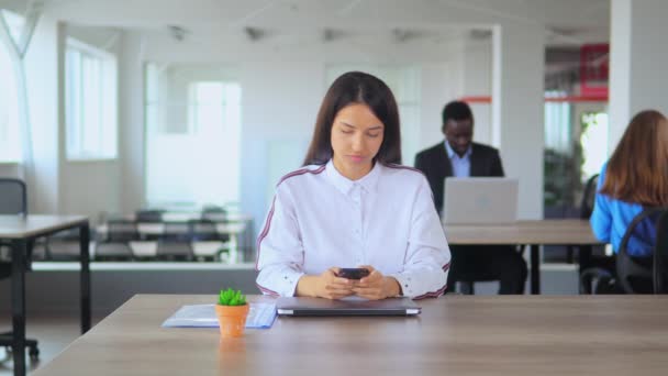 Belle brune riant après avoir vérifié son téléphone — Video