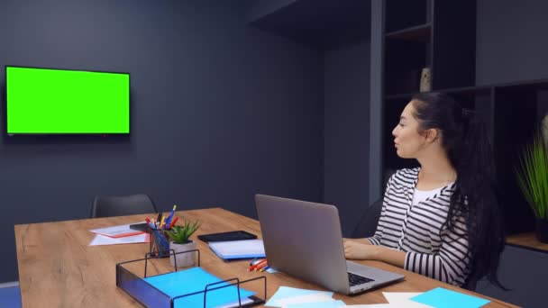 Fröhliches Lachen der arbeitenden Frau, die mit grünem Bildschirm fernsieht — Stockvideo