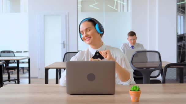 Vrouw die naar muziek luistert in haar hoofdtelefoon in Office — Stockvideo