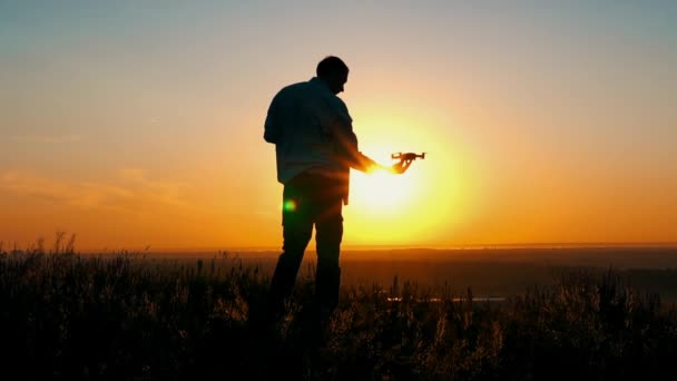 De man lanceert drone bij zonsopgang — Stockvideo