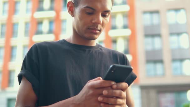 Young man Holding smartphone på gatan i modern stad — Stockvideo