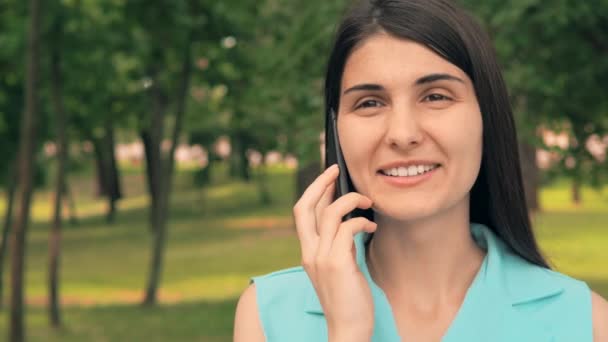 Νεαρή γυναίκα που μιλά από το τηλέφωνο στο δρόμο — Αρχείο Βίντεο