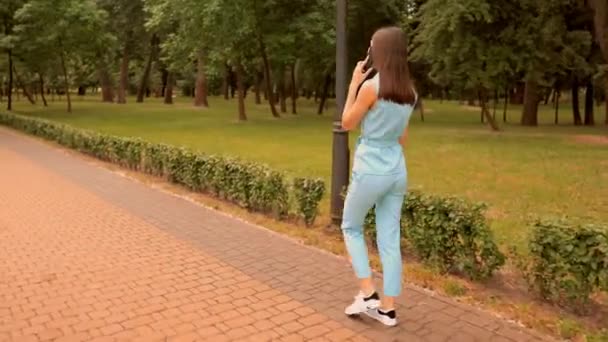 Módní dívka v pohodlných botách na procházce v parku — Stock video