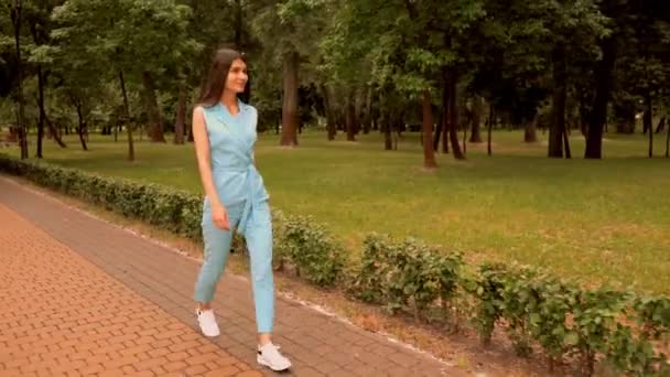 Mujer caminando en la calle en el parque de la ciudad fin de semana de verano — Vídeos de Stock