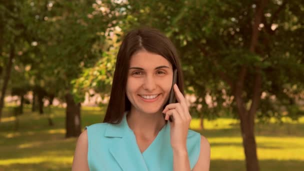 Mobil açık havada konuşan portre neşeli genç kadın — Stok video