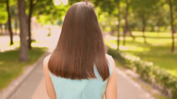 Achteraanzicht close-up vrouw praten per telefoon lopen op de straat stadspark zomer buitenshuis — Stockvideo