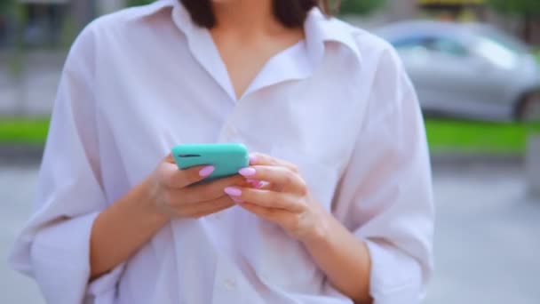 Close up mãos caucasiano mulher segurando smartphone anda urbano cidade fundo — Vídeo de Stock