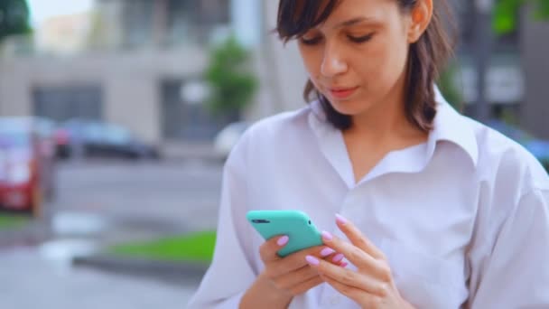 Retrato caucasiano mulher segurando smartphone urbano cidade fundo — Vídeo de Stock