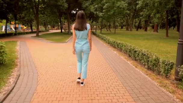 Брюнетка девушка повернитесь к камере улыбаясь прогулки на открытом воздухе летом природный фон — стоковое видео