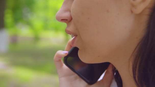 Primer plano perfil chica tiene negociaciones uso de teléfono celular al aire libre — Vídeos de Stock