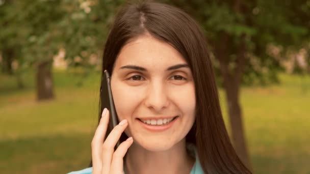 Primer plano cara alegre joven mujer hablando por móvil al aire libre — Vídeos de Stock