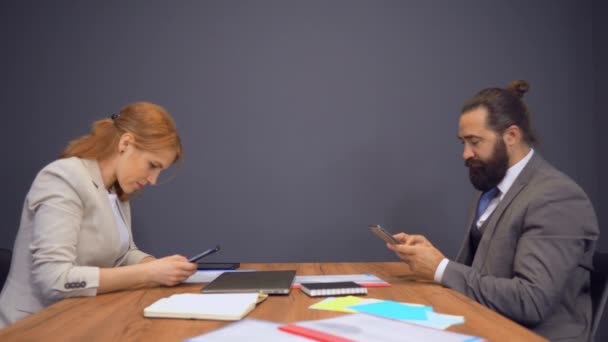 Pessoas de negócios sentadas na sala de reuniões usando dispositivos — Vídeo de Stock