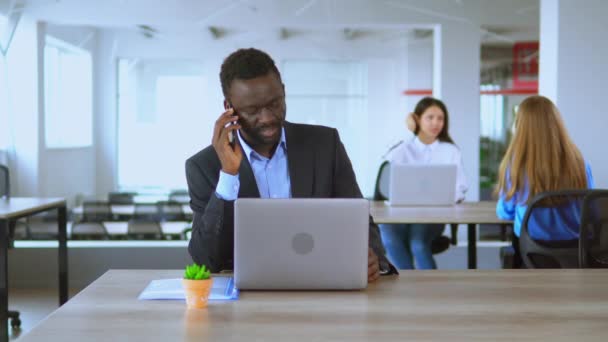 Афроамериканський менеджер консалтингових клієнтів працює у відкритому офісі працівника стартап компанії — стокове відео