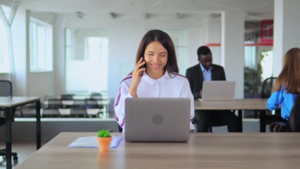 Ung chef har telefonförhandlingar i open space office arbetare i nystartade företag — Stockvideo