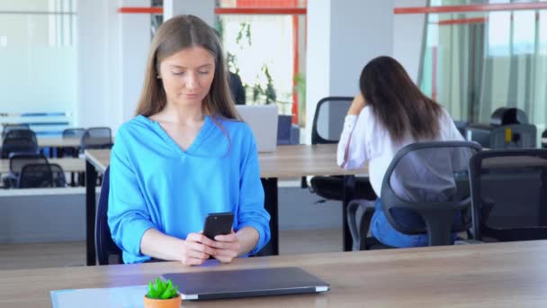 Kaukasische manager met smartphone op de werkplek — Stockvideo