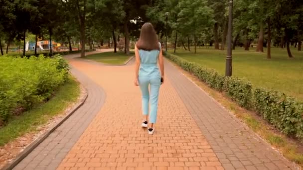 Back view mulher caucasiana alegre andando se divertir na rua no parque da cidade — Vídeo de Stock