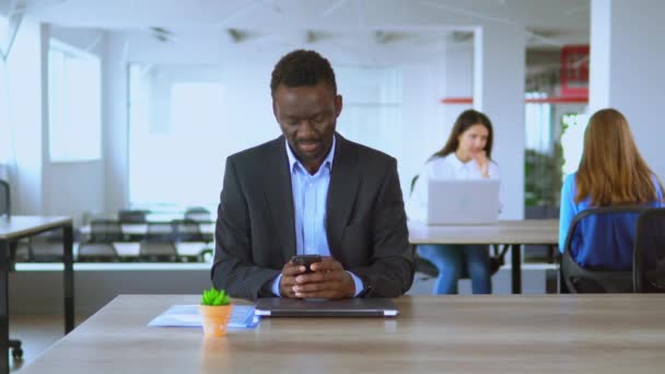 Knappe man kantoor werknemer met behulp van smartphone sms-bericht op de werkplek — Stockvideo
