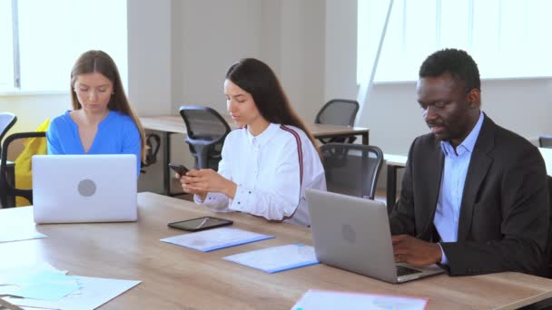 Diversos funcionários sentados no local de trabalho usando dispositivos — Vídeo de Stock