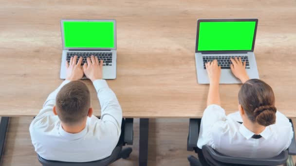 Top view συναδέλφους που κάθονται στο γραφείο χρησιμοποιώντας το laptop — Αρχείο Βίντεο