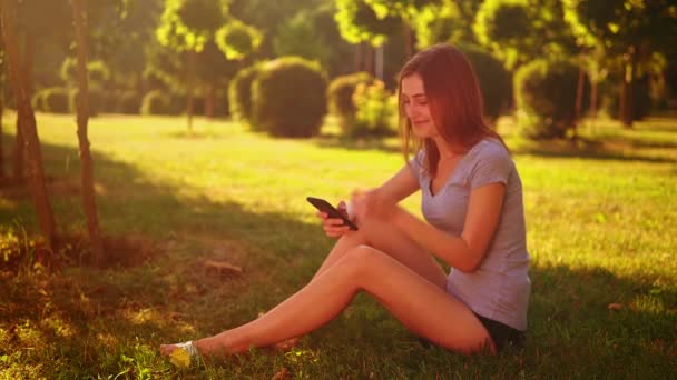 Νεαρή καυκάσια γυναίκα σε casual t-shirt χρησιμοποιούν κινητό τηλέφωνο — Αρχείο Βίντεο