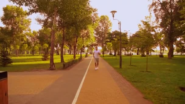 Спортсмен бегает в городском парке — стоковое видео