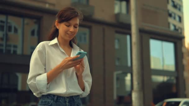 Feliz estudiante desplazamiento pantalla táctil en el móvil — Vídeo de stock