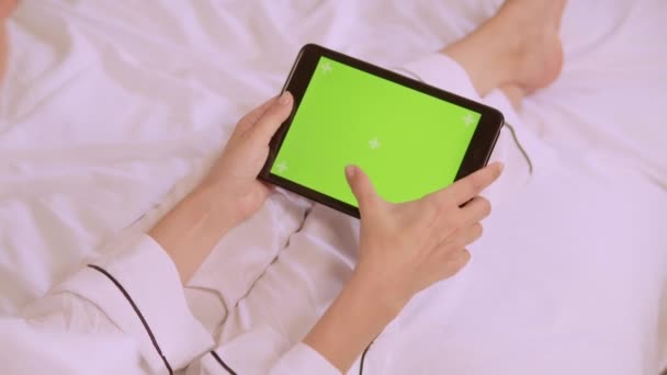 Gros plan femme en pyjama de soie blanche assis sur le lit tenant smartphon — Video