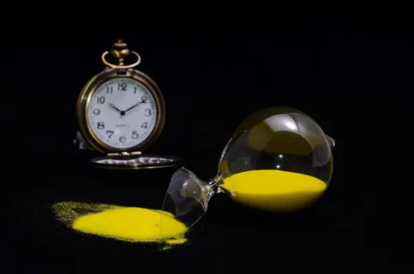 Deadline Concept Broken Hourglass Yellow Sand Black Background — Stock Photo, Image