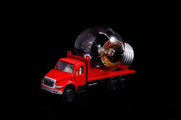 Electric Power Concept Red Truck Light Bulb Black Background — Stock Photo, Image