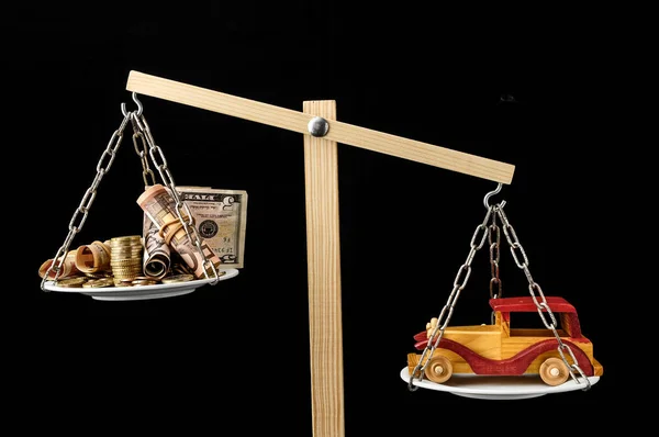 双盘平衡的钱和玩具木车 — 图库照片