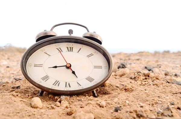 岩石沙漠上的沙子中的经典模拟时钟 — 图库照片