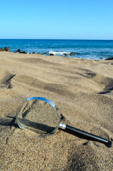 Loupe verre sur la plage de sable — Photo